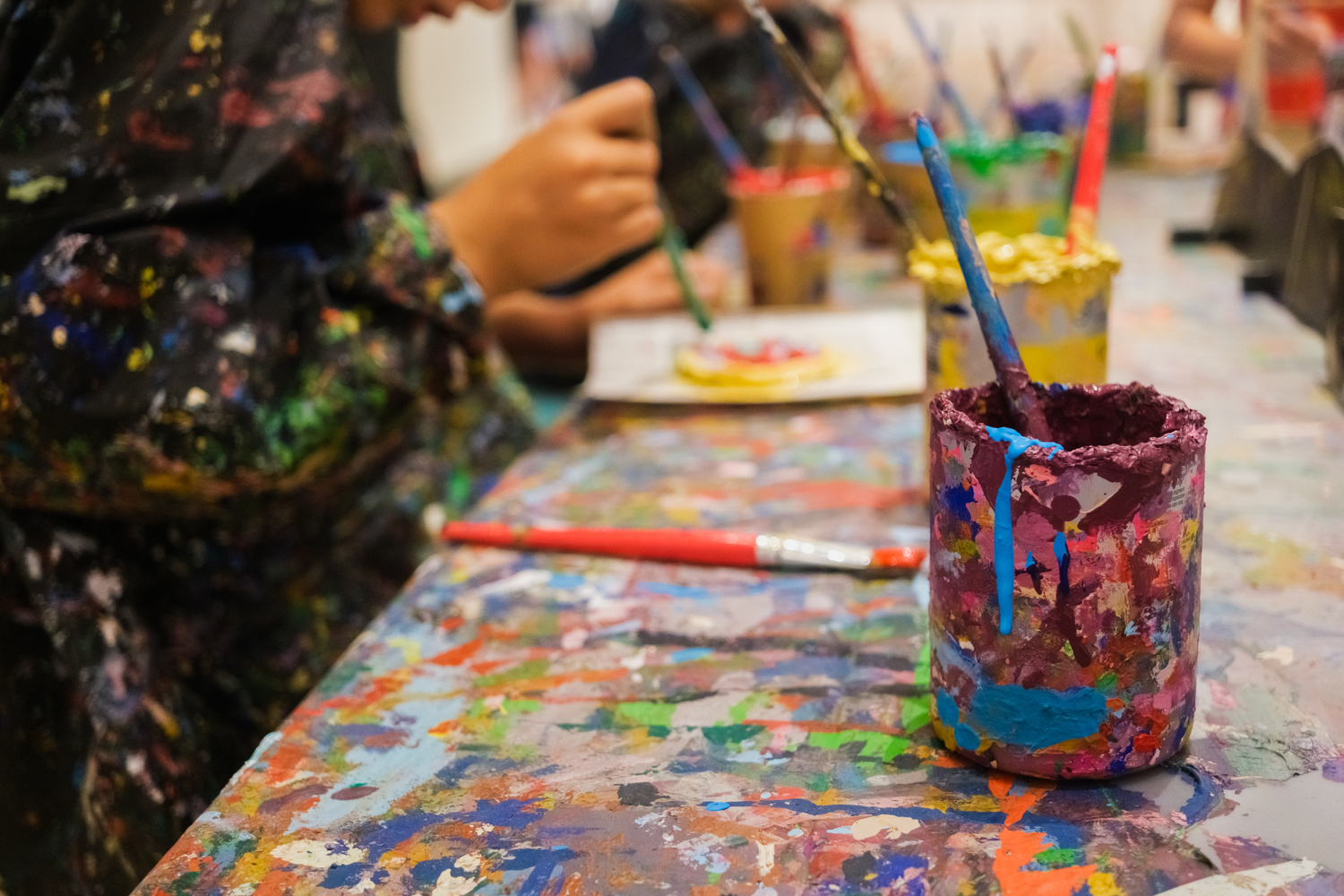Children Enjoy Painting in Art Class, with Hands and Smocks Full of Paint.